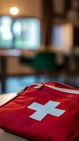 First aid kit placed on a table in a bright room with soft lighting and blurred background photo