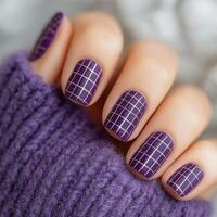 Stylish purple plaid nail design with golden accents on cozy sweater background photo