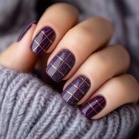 Stylish purple plaid nail design with golden accents on cozy sweater background photo