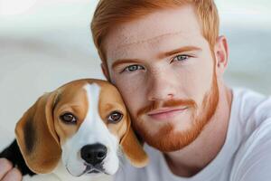 Young man with red hair cuddles beagle puppy at outdoor location during sunny weather photo