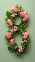 Floral arrangement of pink tulips shaped like the number eight on a pastel background photo