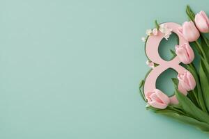 Decorative arrangement of pink tulips alongside a number eight on a light turquoise background photo