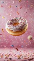 Delicious donut with sprinkles flying above colorful candy decorations photo