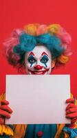Colorful clown with vibrant wig holds sign in front of bright pink background photo