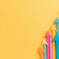 Colorful arrows pointing upwards on a yellow background symbolize growth and progress photo