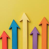 Colorful arrows pointing upwards on a vibrant yellow background illustrating growth and progress photo