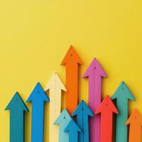 Colorful arrows pointing upwards on a vibrant yellow background illustrating growth and progress photo