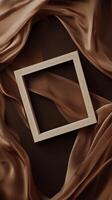 Unique wooden frame on a backdrop of flowing brown fabric in an artistic setting photo