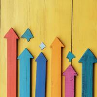 Colorful arrows pointing upwards on a vibrant yellow background illustrating growth and progress photo