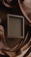 Unique wooden frame on a backdrop of flowing brown fabric in an artistic setting photo
