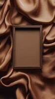 Unique wooden frame on a backdrop of flowing brown fabric in an artistic setting photo