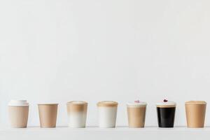 Different styles of coffee cups arranged in a row on a light background showcasing variety photo