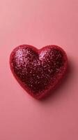 Shiny red heart shaped decoration on soft pink background for festive occasions photo