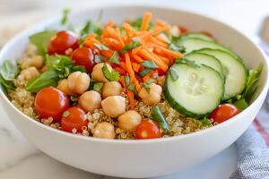 Healthy quinoa salad with cucumbers, tomatoes, and chickpeas served in a bowl photo