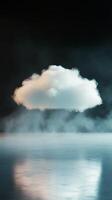 Cloud hovering above calm water with mist in serene atmosphere photo