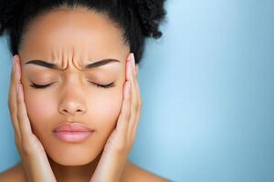 Woman with closed eyes relaxing while holding her face, expressing peaceful emotions photo