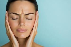 Woman with closed eyes relaxing while holding her face, expressing peaceful emotions photo