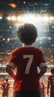 Young fan admires players in red jerseys at stadium during energetic soccer match photo