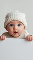 Cheerful baby expressing surprise while peeping over a blank surface in a cozy setting photo