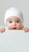 Cheerful baby expressing surprise while peeping over a blank surface in a cozy setting photo
