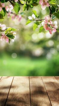 Wooden table with blooming flowers and soft green background in springtime setting photo