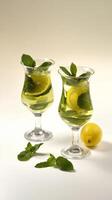 Refreshing lemon and mint beverage served in tall glasses with bubbles and garnishes photo