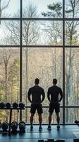 Two individuals enjoying a workout view from a gym overlooking a lush green landscape photo