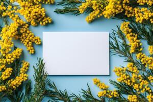 Bright yellow flowers surrounding a blank white card on a textured blue background photo