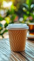 Coffee cup on wooden table surrounded by greenery in a cozy cafe setting during the afternoon photo