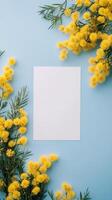 Bright yellow flowers frame a blank paper on a blue background creating a cheerful atmosphere photo