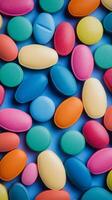 Colorful capsules scattered on a smooth surface creating a vibrant abstract pattern photo