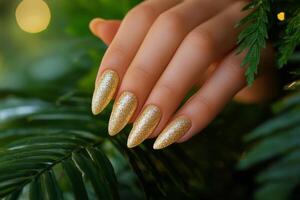 Elegant gold glitter nail design with soft green background showcasing manicured hands photo
