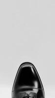 Elegant black dress shoes positioned for a formal occasion on a blank background photo