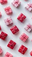 Collection of beautifully wrapped pink and red gifts arranged artistically on a light background photo