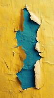 Cracked wall revealing blue texture beneath yellow surface in an artistic display photo