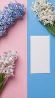Colorful arrangement of spring flowers and blank card on vibrant background photo