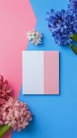 Colorful arrangement of spring flowers and blank card on vibrant background photo