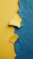 Cracked wall revealing blue texture beneath yellow surface in an artistic display photo