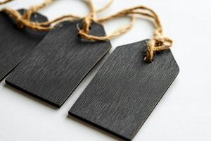 Rustic black tags with twine arranged on a surface for labeling and crafts photo