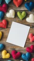 Colorful heart decorations surround an empty note on a wooden table photo