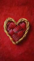Woven heart made of red and natural fibers on a vibrant red background photo