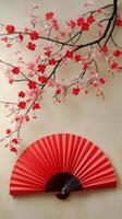 Elegant red floral arrangement with a decorative fan against a light background photo
