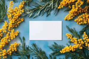 Bright yellow flowers surrounding a blank white card on a textured blue background photo