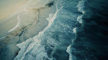 Waves crashing on sandy beach during sunny day photo