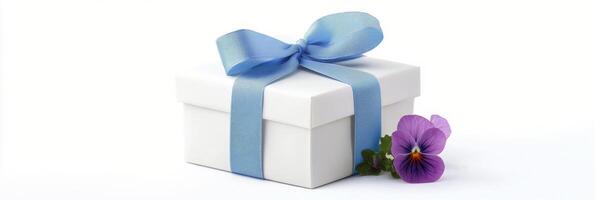 Elegant gift box wrapped in blue ribbon with flowers on a light background photo