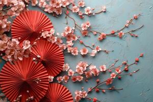 Colorful paper fans and cherry blossoms create a vibrant decorative display on a blue background photo