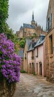 Charming cobblestone street lined with vibrant flowers in a historic village with castle backdrop photo