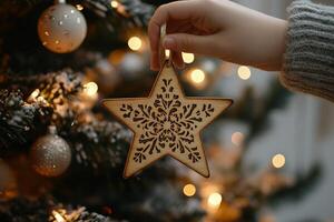 Handmade wooden snowflake ornament hanging on a Christmas tree decorated with lights photo