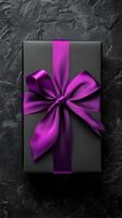 Elegant black gift box with purple ribbon ready for a special occasion photo