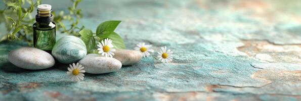 Two small bottles of essential oil placed on a smooth stone with herbs and flowers photo